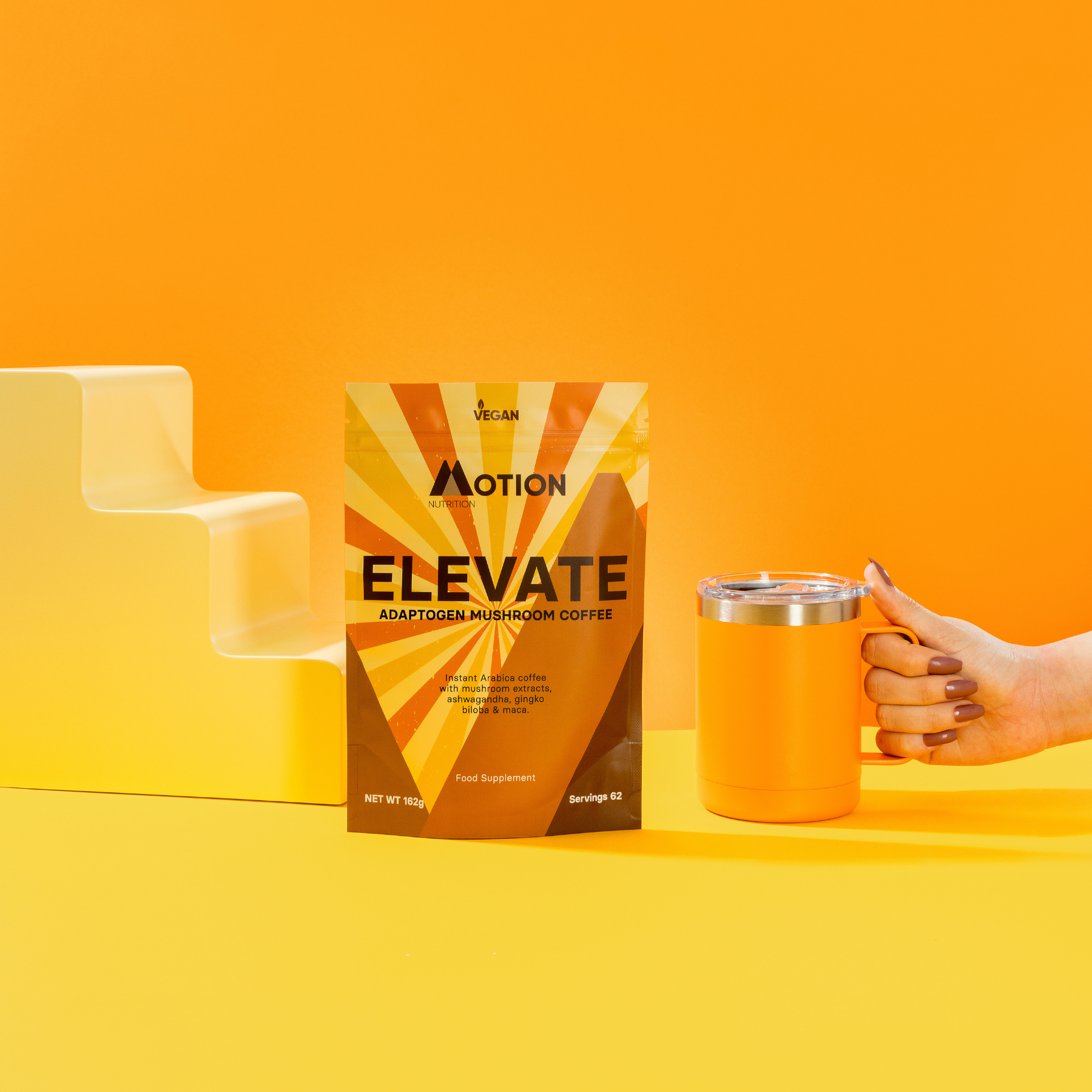 Action Elevate adaptogen mushroom coffee package with a hand holding an orange mug on an orange background